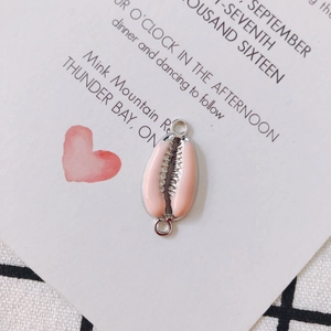 Detail of pink enamel shell pendant connector with silver metal rings for DIY jewelry