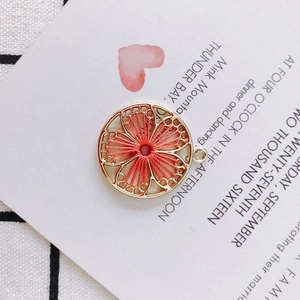 Handmade woven flower pendant with coral red silk thread and golden metal circular frame