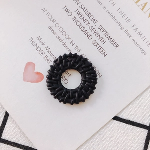 Close-up of black woven circular resin jewelry charms with intricate DIY craft texture
