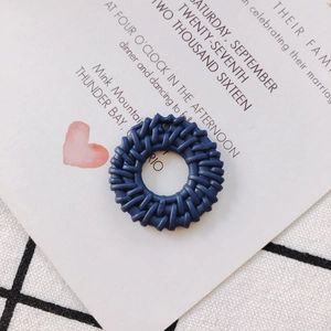 Close-up of navy blue circular resin charm with intricate woven texture for DIY earrings