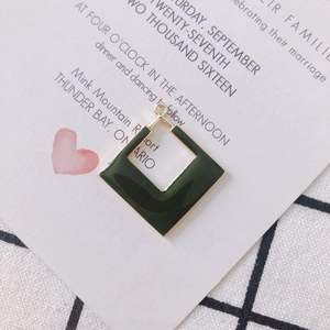 Détail d'un pendentif géométrique en émail vert avec cadre doré sur une carte décorative