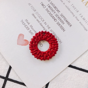 Macro shot of red round woven earring charms for DIY jewelry making on aesthetic card