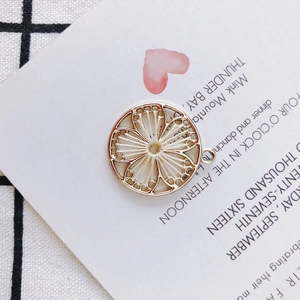 Macro shot of gold alloy round pendant with white woven bohemian flower pattern