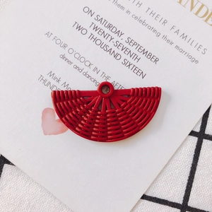 Vue macro d'un pendentif en résine rouge en forme d'éventail avec texture tressée pour DIY