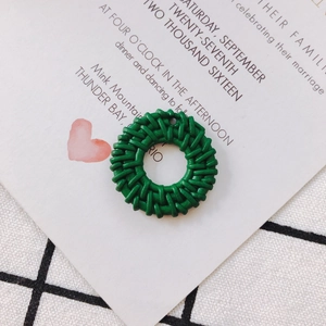 Detail of green woven round pendant with hollow rattan pattern for DIY jewelry making