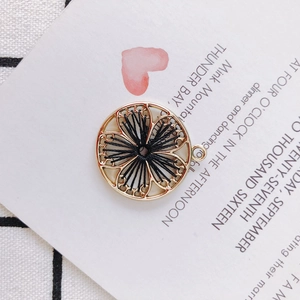 Detail of round gold hollow charm with black woven thread for DIY jewelry making
