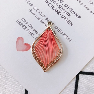 Detailed macro view of drop-shaped coral thread wrapped alloy pendant for DIY jewelry