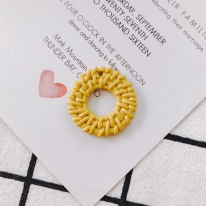 Detail of a round woven yellow pendant for DIY jewelry making with intricate texture