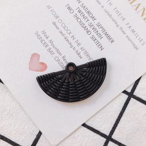 Détail d'un pendentif noir en résine en forme d'éventail avec texture tissée pour bijoux
