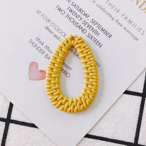 Detalle macro del colgante ovalado amarillo de resina con textura de ratán para joyas DIY