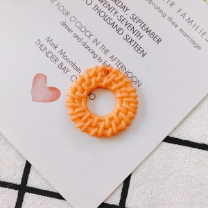 Close-up of round orange hollow pendant with woven texture for DIY jewelry making