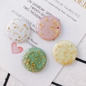 Detail of round acrylic pendants with gold foil in white, pink, mint, and yellow for DIY jewelry