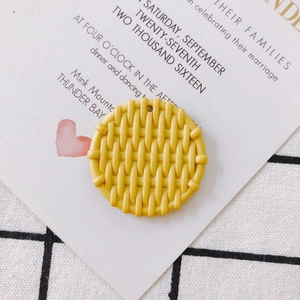 Macro view of bright yellow woven resin round pendant with top hole for DIY jewelry