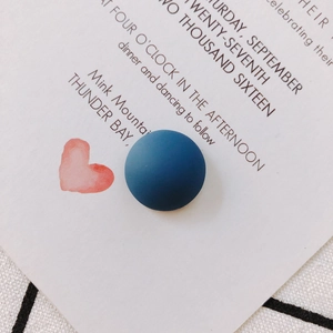 Macro shot of matte navy blue resin circular cabochon for DIY crafts on a textured background