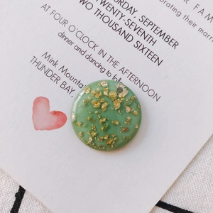 Close-up of green resin round pendant with gold foil flakes for DIY jewelry making