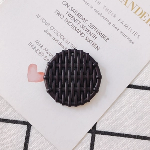 Close-up of a dark brown round woven resin pendant for DIY jewelry and earrings