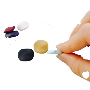 Perle rotonde piatte colorate per la creazione di gioielli fai da te tenute in mano su sfondo bianco