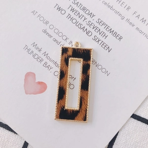 Macro detail of rectangle leopard print pendant with gold metal frame for DIY jewelry