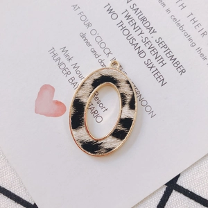 Macro detail of oval alloy leopard print pendant with gold frame for DIY jewelry making