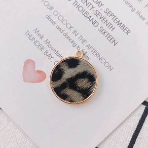 Détail macro du pendentif rond imprimé léopard avec cadre doré pour création de bijoux