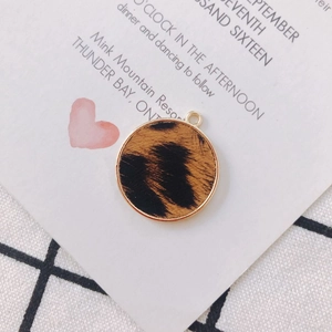 Gros plan d'un pendentif rond imprimé léopard avec bordure dorée pour bijoux DIY