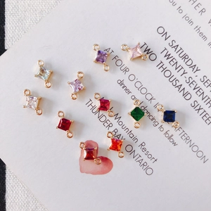 Makroaufnahme bunter quadratischer Zirkon-Verbinder mit vergoldeten Ösen für DIY-Schmuck