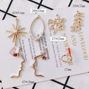 Set mit goldenen unregelmäßigen geometrischen DIY-Anhängern und Perlen auf Hintergrund