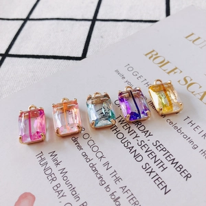 Macro view of five-color gradient rectangular faceted crystal charms with claw settings