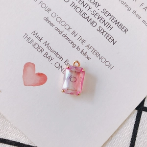 Macro view of a pink gradient rectangular crystal pendant with gold claw setting