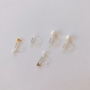 Detailed view of DIY invisible resin ear clip converters with gold and pearl accents