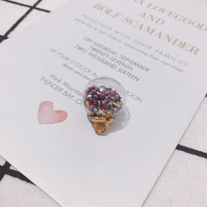 Macro detail of a transparent glass ball pendant filled with colorful glitter and sequins