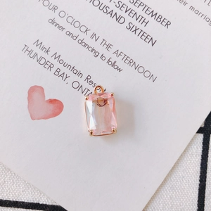 Close-up of a pink faceted crystal pendant with a gold claw setting and bail