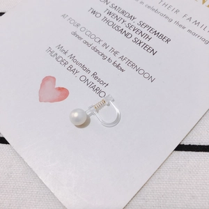Detail of elegant white pearl earring with invisible resin spring clip for non-pierced ears