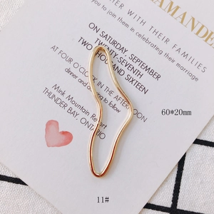 Nahaufnahme des goldenen welligen Geometrie-Anhängers 60x20mm für DIY-Ohrringe