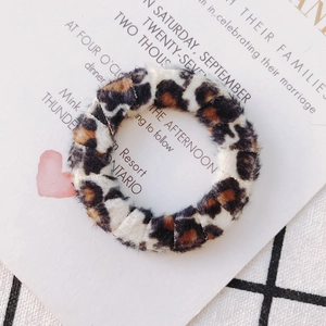 Détail d'un chouchou élastique en fausse fourrure léopard avec texture douce marron et noir