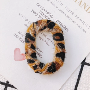 Détail d'un accessoire de boucle d'oreille rond léopard sur une carte d'invitation
