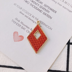 Primer plano de colgante romboide dorado con cuero naranja para creación de joyas DIY