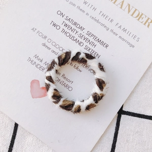 Gros plan d'un apprêt pour boucles d'oreilles en tissu léopard avec texture douce