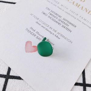 Detail of matte green apple-shaped 925 silver stud earring on a clean background