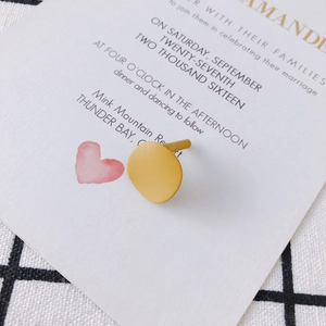 Detail of yellow geometric irregular round stud earring with a matte painted finish