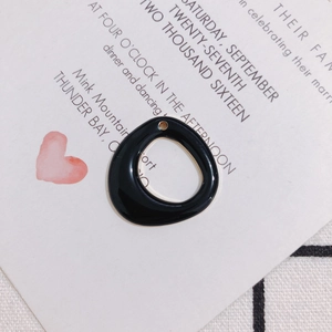 Macro view of a black glossy irregular circular charm for DIY jewelry making