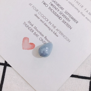 Close-up of light blue teardrop faux pearl bead with pre-drilled hole for DIY jewelry