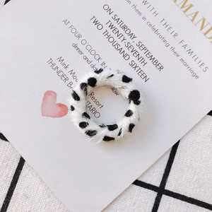 Détail d'un anneau de boucle d'oreille en fausse fourrure douce avec motif vache