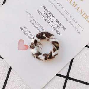 Gros plan de composants de boucles d'oreilles ronds à imprimé léopard sur carte
