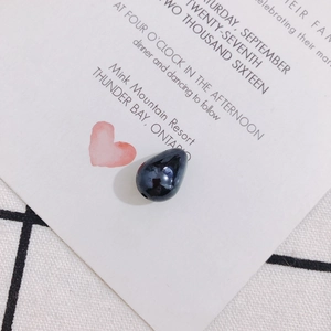 Close-up of a polished dark blue teardrop pearl bead with a pre-drilled hole for DIY jewelry