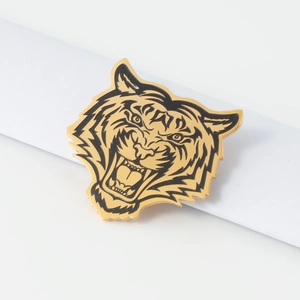 Broche tête de tigre en acier inoxydable doré 18 carats avec détails noirs sur fond blanc