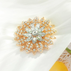 Broche fleur dorée élégante avec cristaux brillants sur fond de soie blanche