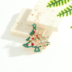 Golden Christmas tree brooch with green and red rhinestones on travertine stone