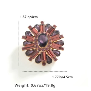 Detail view of round floral brooch with purple rhinestones showing size and weight