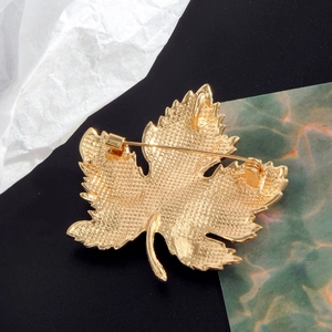 Vue arrière de la broche feuille d'érable rose dorée avec texture métal et fermoir